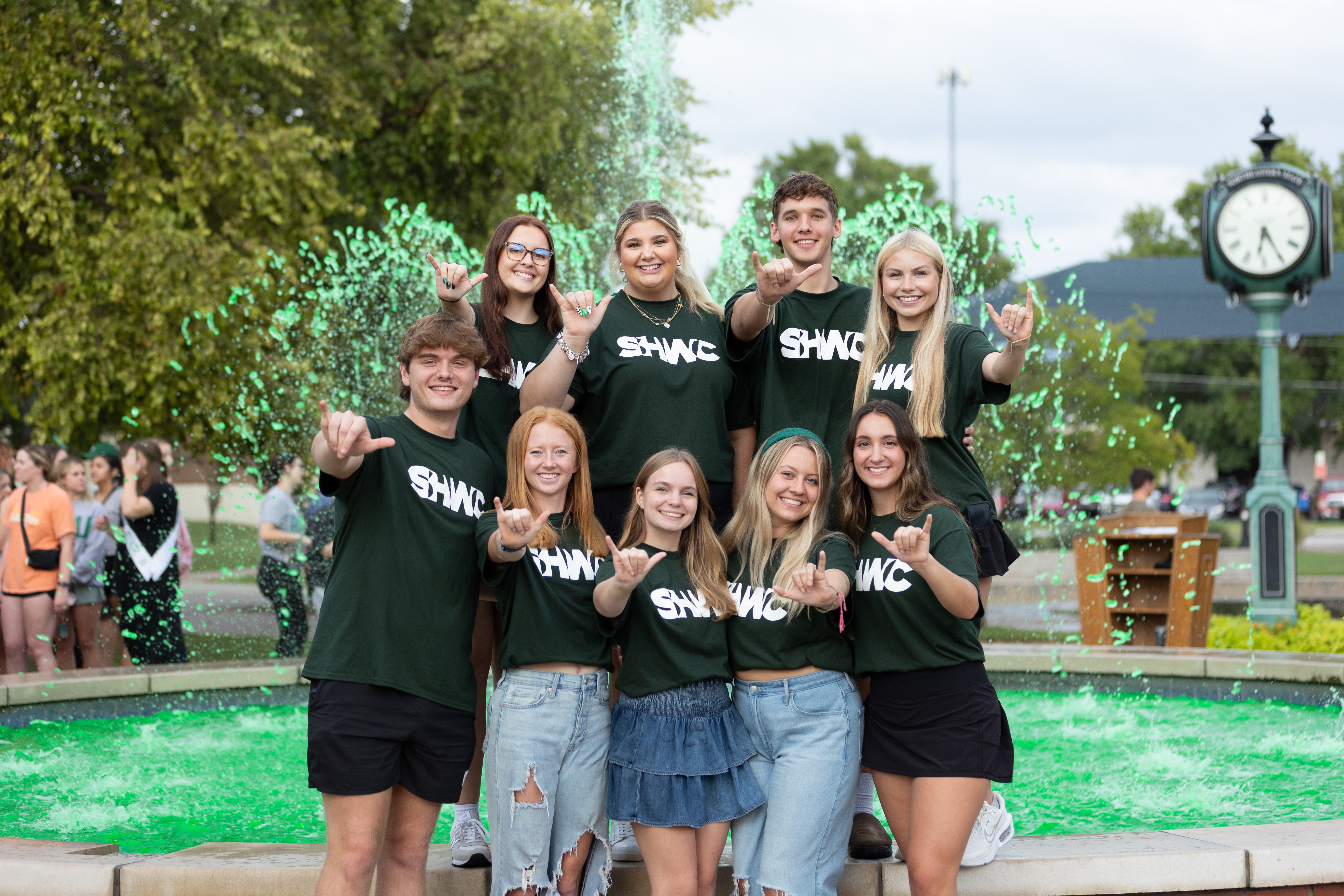 Students Standing in Front of Water Fountain